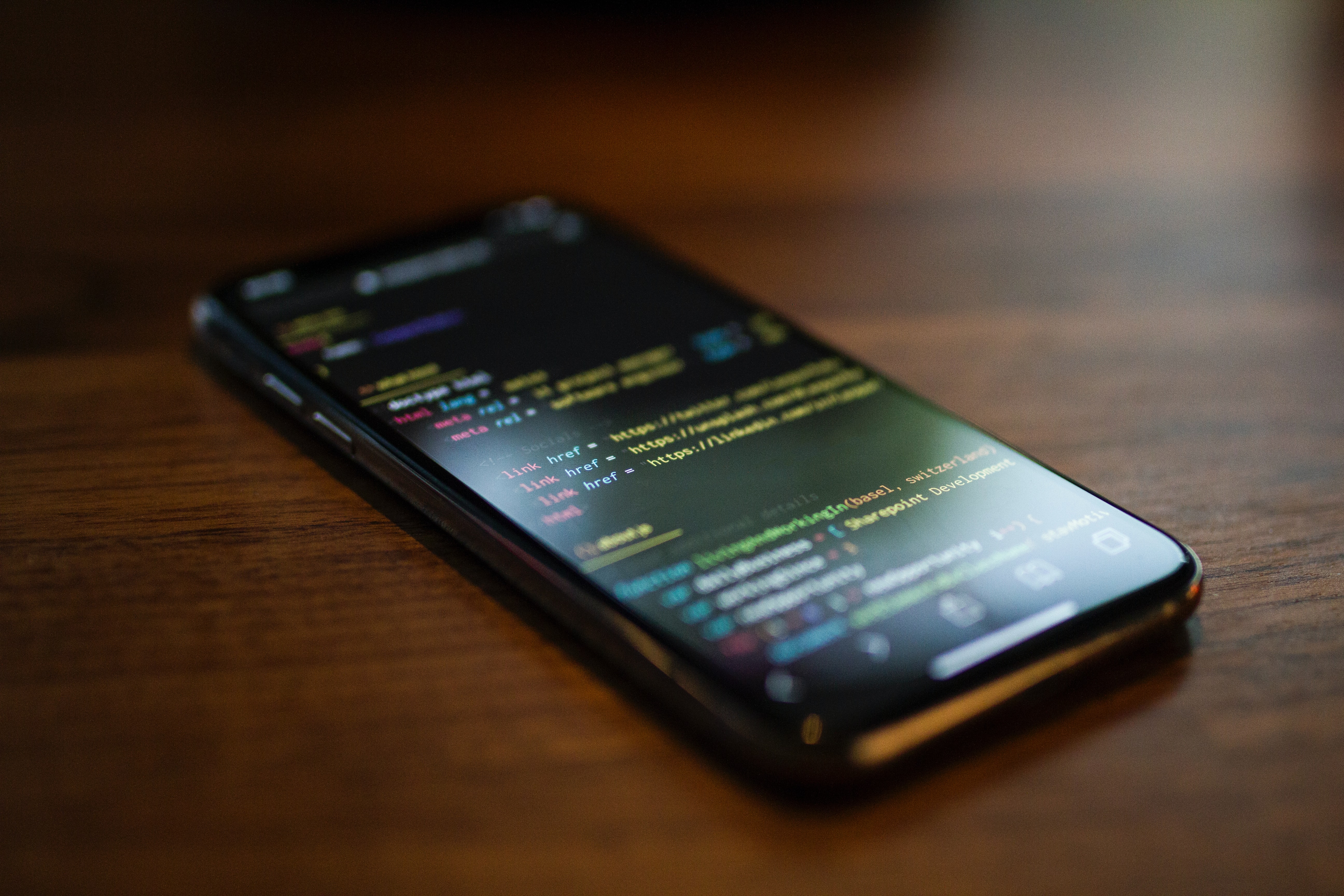 A smartphone on a table displaying source code